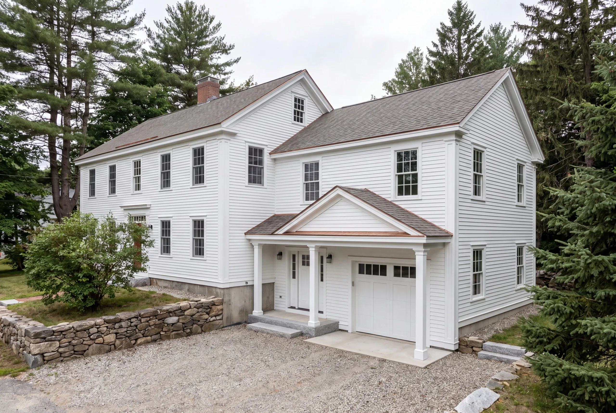 ADU builder Hallowell Maine: white clapboard wing with a one-bay garage and covered entry joined to a colonial