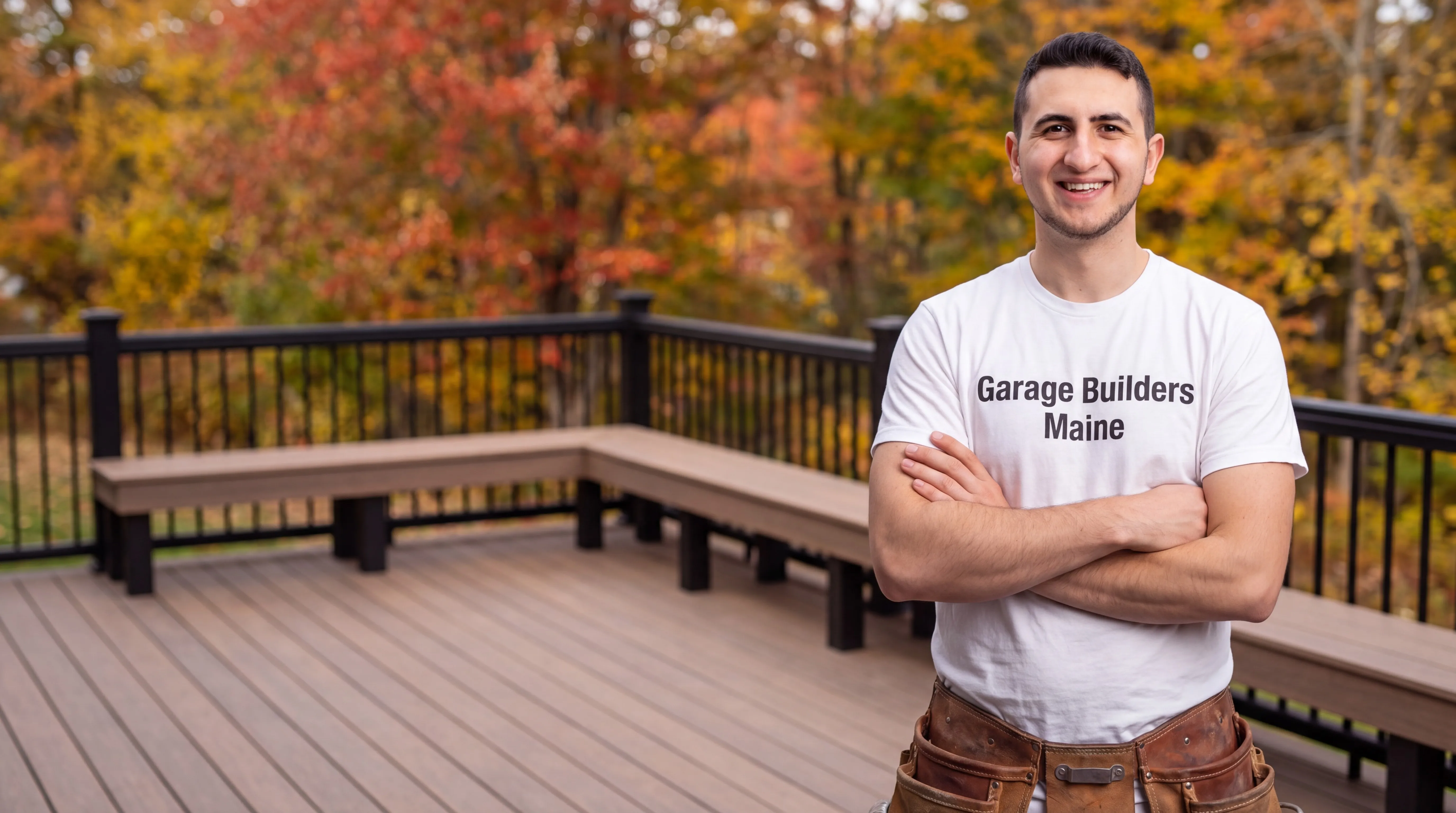 Deck contractor Augusta Maine: owner with arms crossed on a brown composite deck with a built-in bench