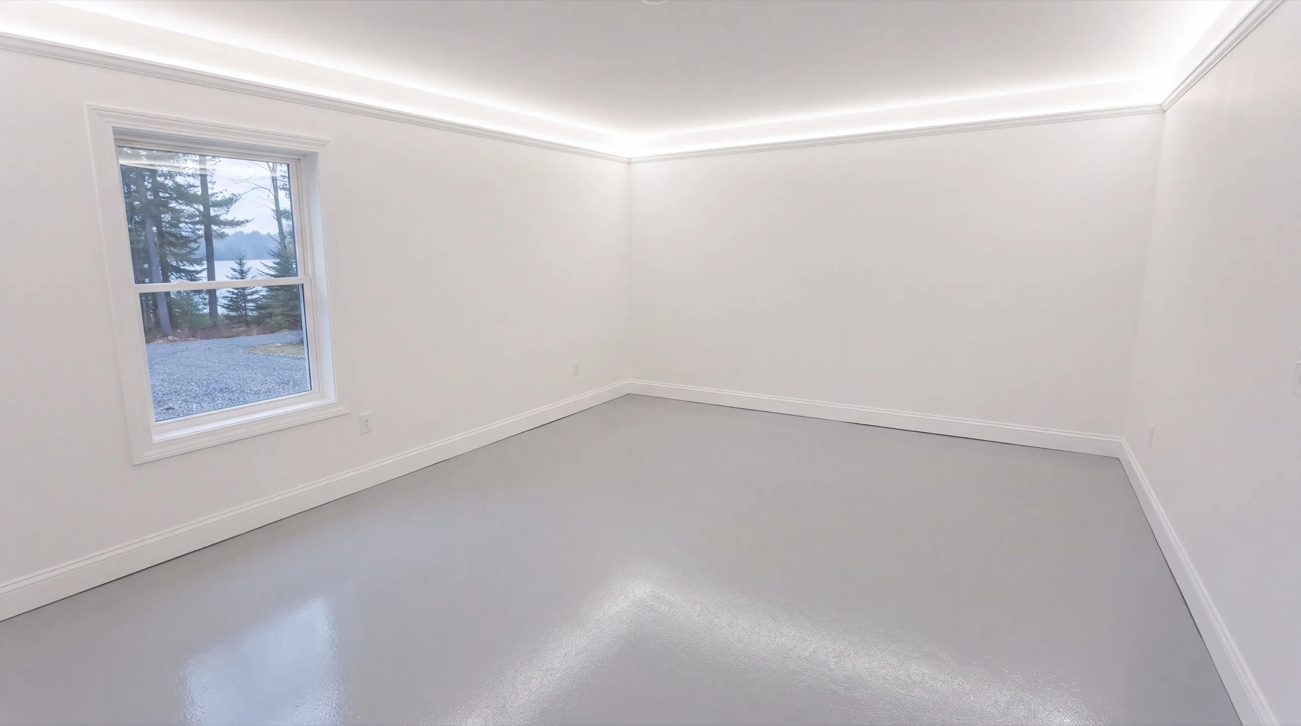 Garage remodeling in Manchester, ME: finished white garage room with a coated gray floor and one window
