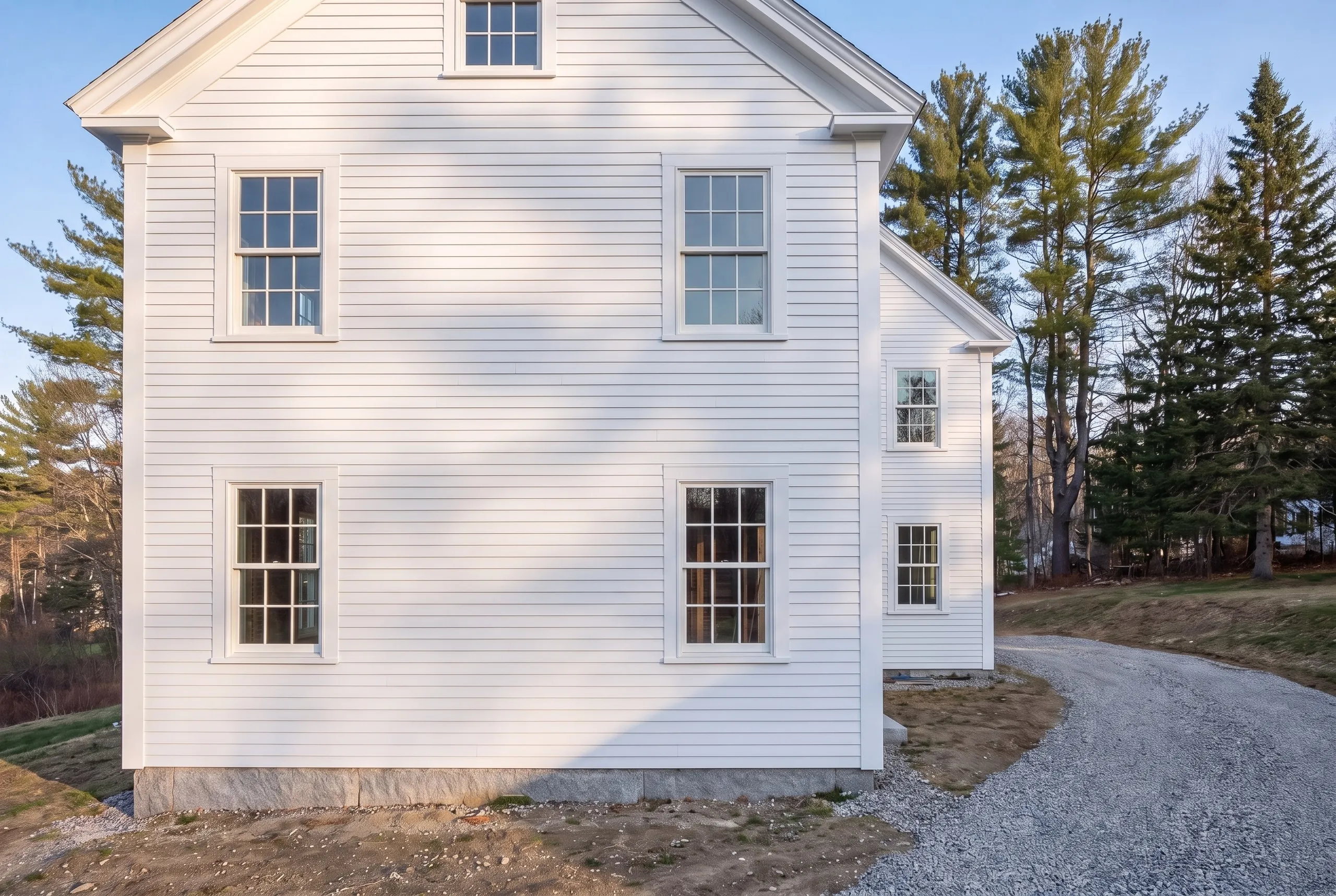 General contractor Gardiner Maine: white clapboard house on a granite foundation, bare stud walls showing through the lower windows
